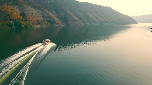 Motorboat Gliding Down Tranquil River at Sunset
