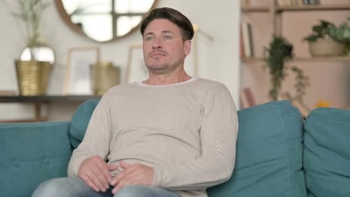 Man Stands Up From Couch