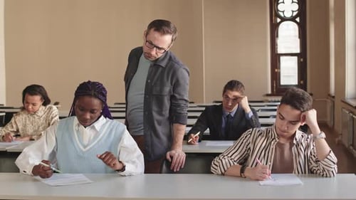 Diverse Students Take Test in Classroom with Teacher