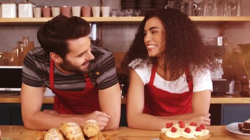 Smiling Cafe Workers Behind Counter with Pastries