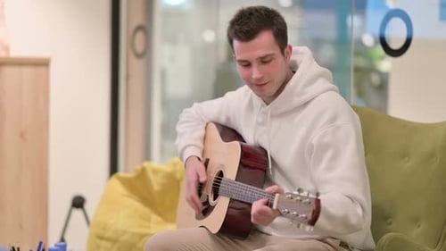 Young Adult Plays Guitar at Home