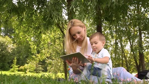 Mother and Child Interact With Tablet in Park