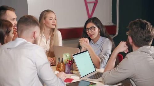 Woman Is Presenting Her Idea for Colleagues in Small Meeting in Office