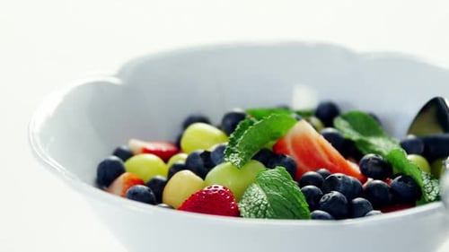 Delicious Fruit Salad in White Bowl with Mint