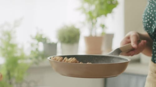 Toasting Walnuts in a Pan in a Kitchen