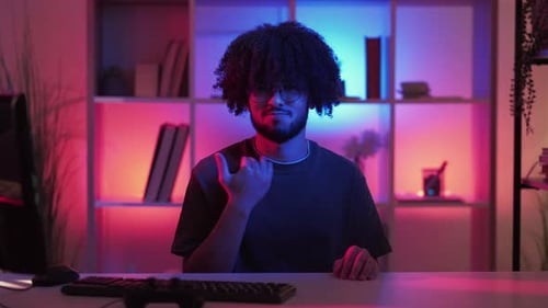 Young Adult at Desk with Neon Lights