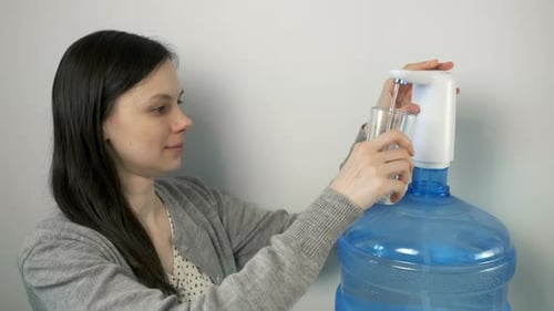 Woman Gets Fresh Water From Water Cooler
