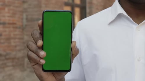 Builder Holding Smartphone with Chroma Key Screen