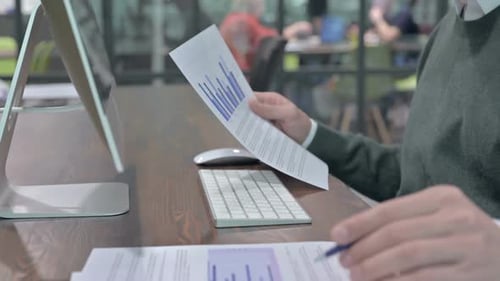 Nahaufnahme der Menschenhand beim Schreiben und Überprüfen der Dokumente