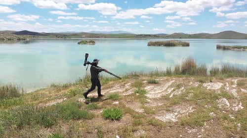 Photographer Walking By The Lake