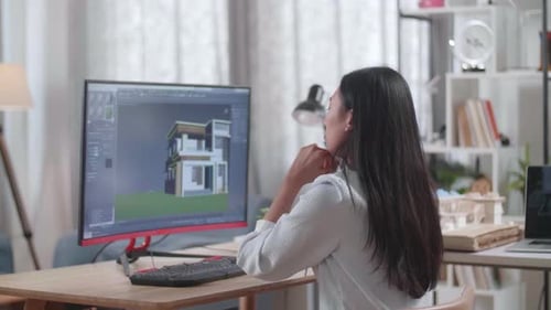 Asian Woman Engineer Thinking While Designing House On A Desktop At Home