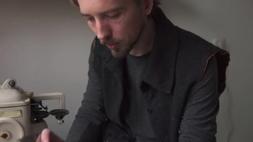 Jeune homme beau tailleur travaillant dans l'atelier du cuir
