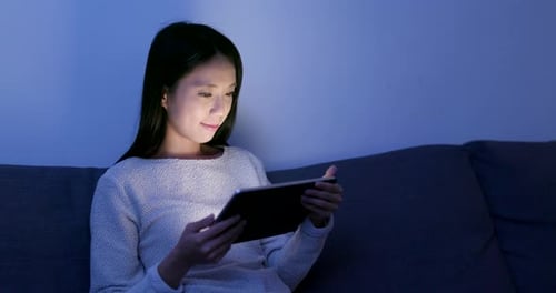 Woman use of tablet computer at night