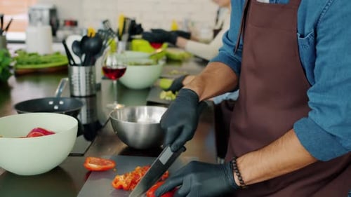 Chef Slicing Red Peppers in Commercial Kitchen