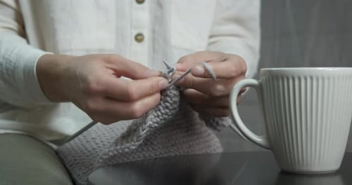 Hands Knitting Gray Yarn with Knitting Needles