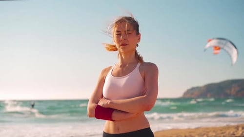 Fit Woman with Arms Crossed on Windy Beach