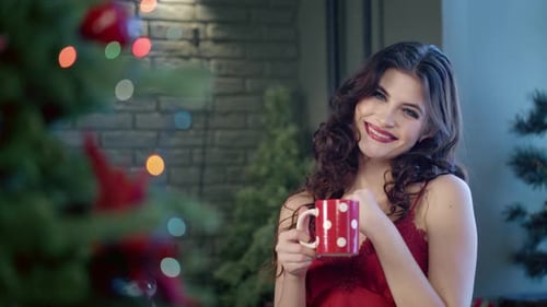 Smiling Woman with Mug near Christmas Tree
