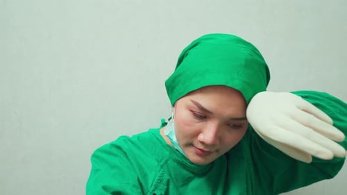 Tired Woman Doctor in Surgical Scrubs and Mask