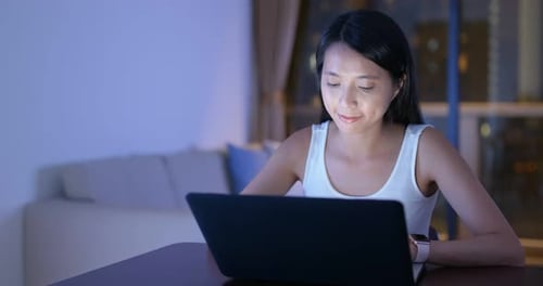 Woman Working on Laptop at Night