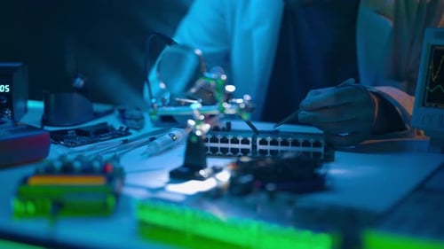 Person repairing electronics in lab at night