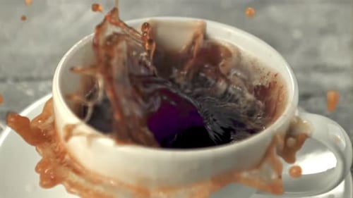Super Slow Motion in a Mug of Coffee Drops a Piece of Sugar with Splashes
