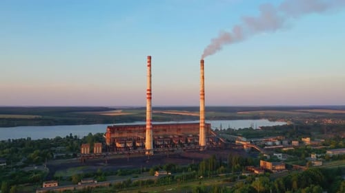 Industriegebiet mit Kaminen bei Sonnenuntergang. Panoramablick auf Rohre mit Rauch der Fabrik