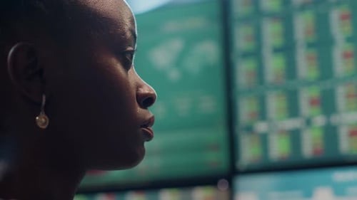Woman Looks at Computer Screens in Modern Office
