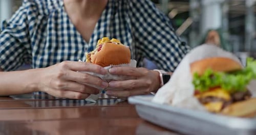 Woman eat burger in fast food restaurant