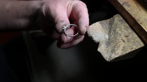 Closeup of Wedding Ring Polishing By Caicasian Jeweler Isolated Footage