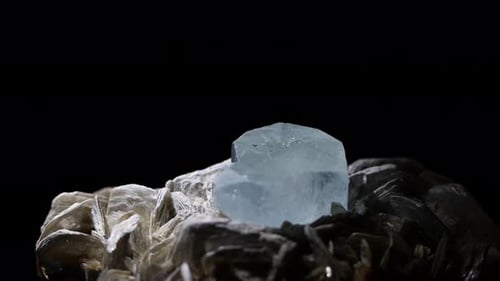 La belleza de un cristal aguamarina de cerca en una toma macro. La muestra brilla en su matriz de m