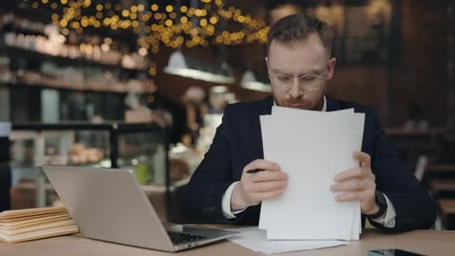 Focused Man Working on Laptop in Cafe
