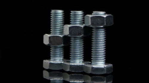 Metal Nuts and Bolts on Reflective Surface