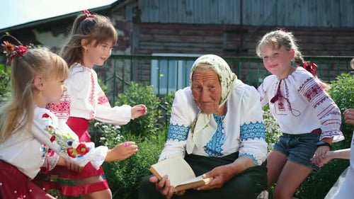 An Old Grandmother is Sitting on the Street and Reading a Book