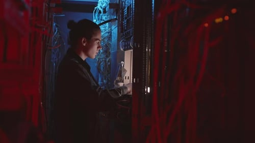 Young Adult Working in Dark Server Room