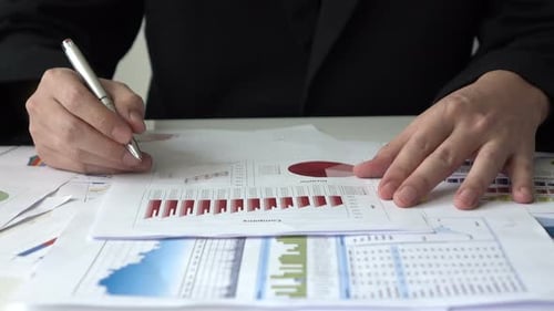 Man Reviews Charts and Graphs in Workplace