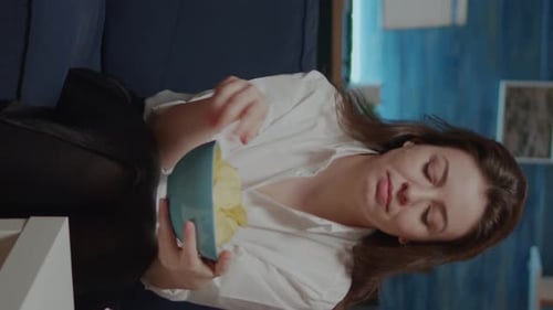 Woman Eating Chips Indoors at Home