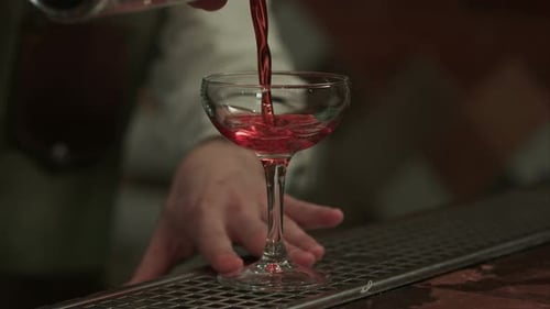 Bartender Prepares Red Cocktail in Elegant Glass