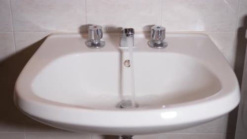 Water Running Into Sink in Bathroom