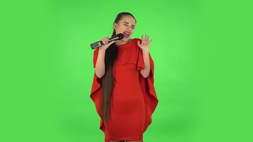 Hübsche junge Frau singt in ein Mikrofon und bewegt sich im Takt der Musik