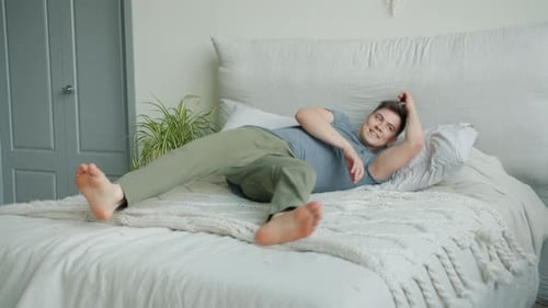 Young Adult Lying Comfortably on Made Bed
