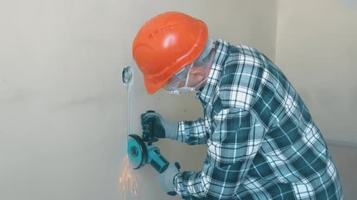 Man Cutting Wall with Electric Hand Tool