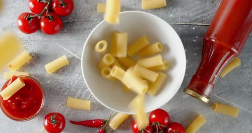 Rigatoni Falling into Bowl with Tomatoes and Sauce