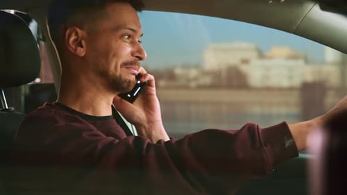 Young Man Talking on Phone While Driving Car