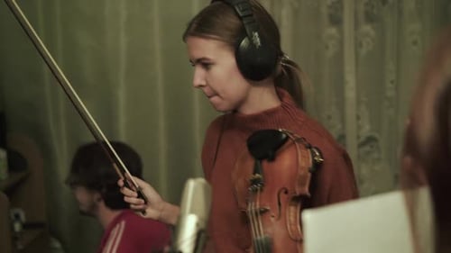 Young Woman Playing Violin During Recording Session