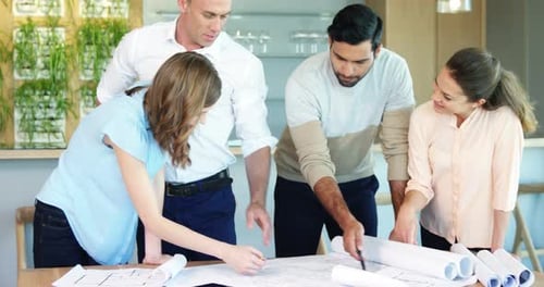 Business people working on blueprint at table in a modern office 4k