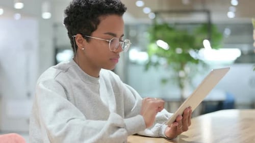Young Adult Using Tablet at Bright Workplace Desk