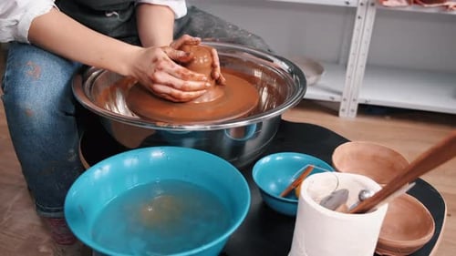 Person Shaping Clay on Potter's Wheel