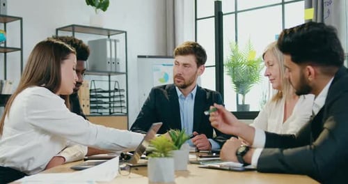 Businesspeople Brainstorming Together in Office Room During Joint Meeting, Business Concept