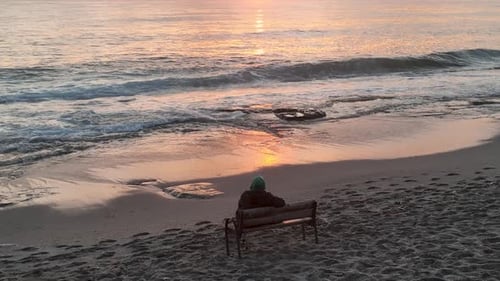 People sit on the beach and watch the sunset