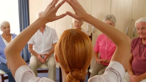 Seniors Doing Gentle Arm Exercises in Group Setting